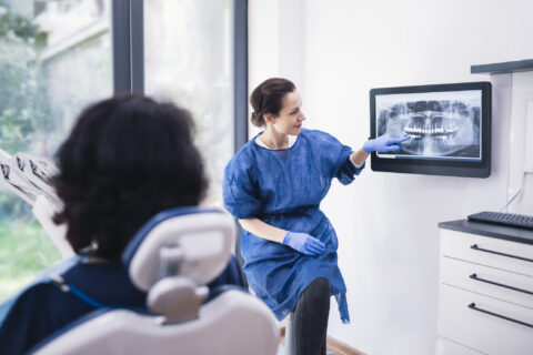 Dentist explaining tooth x-rays to a patient